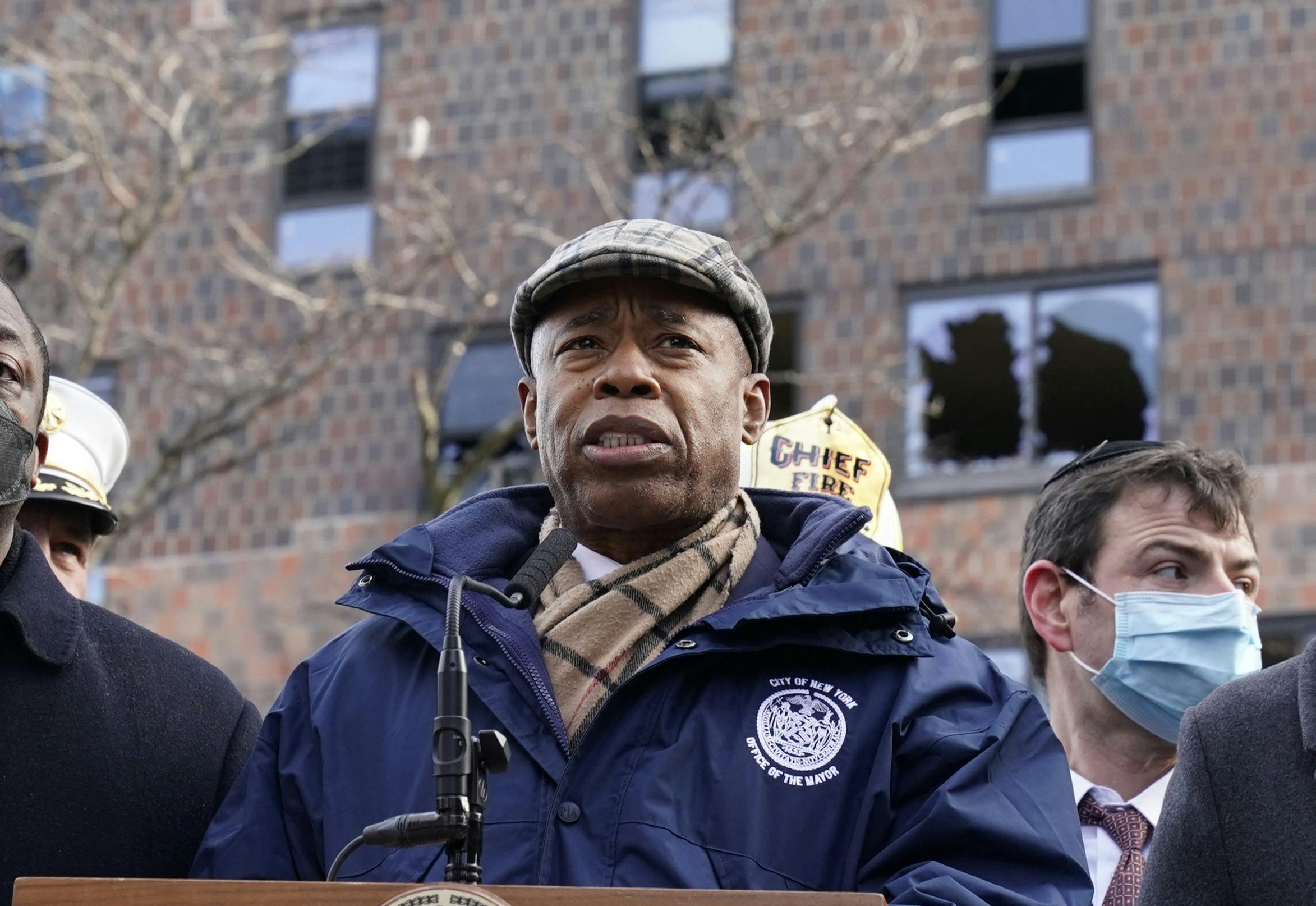 New York City Mayor Eric Adams stands in front of a Bronx apartment building
