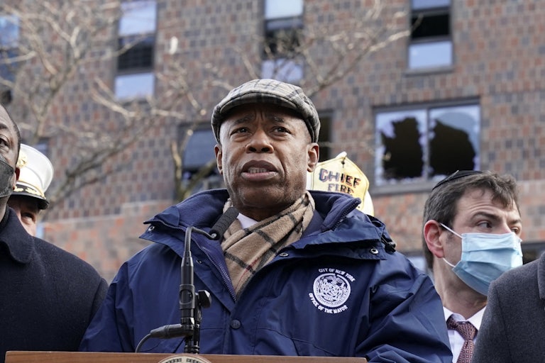 New York City Mayor Eric Adams stands in front of a Bronx apartment building
