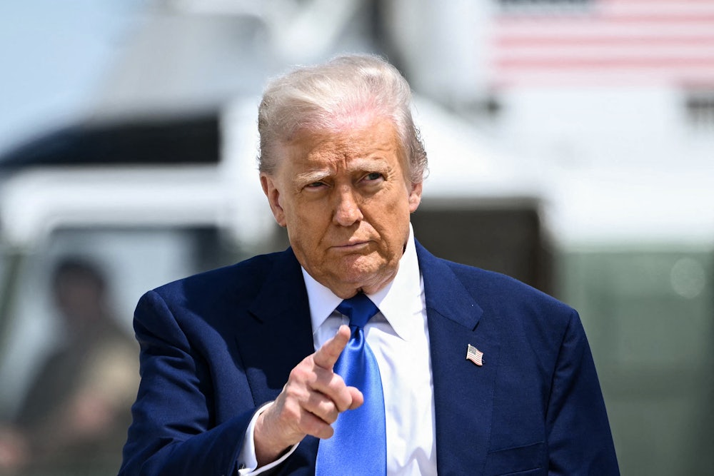 Donald Trump points while walking on an airport tarmac