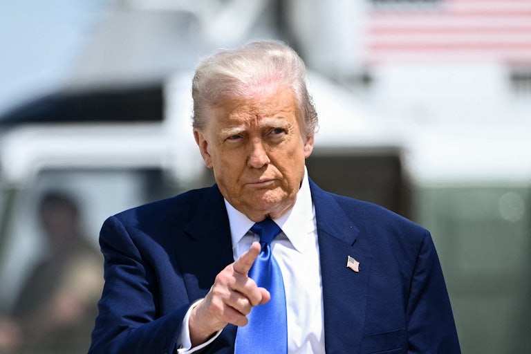 Donald Trump points while walking on an airport tarmac