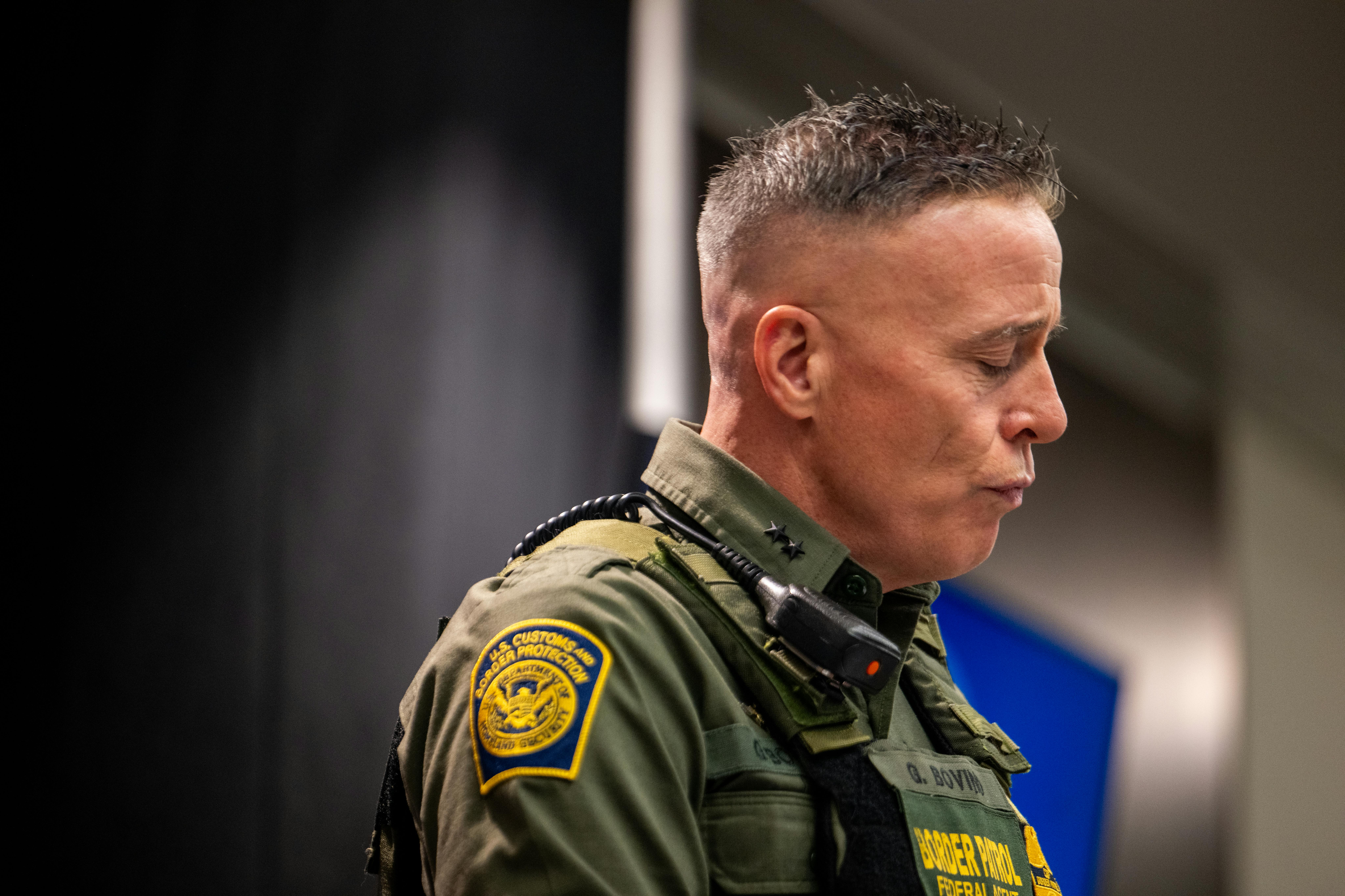 CBP Commander Gregory Bovino purses his lips and looks down during a press conference