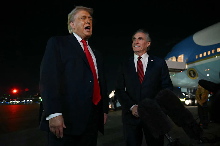 Donald Trump and Secretary of the Interior Doug Burgum speak to reporters outside a plane