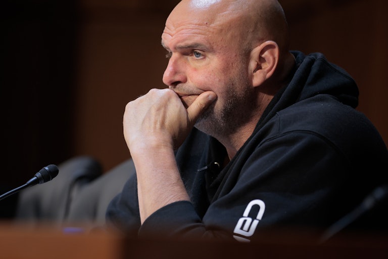 Pennsylvania Senator John Fetterman puts his chin on his hand as he listens in a congressional hearing.