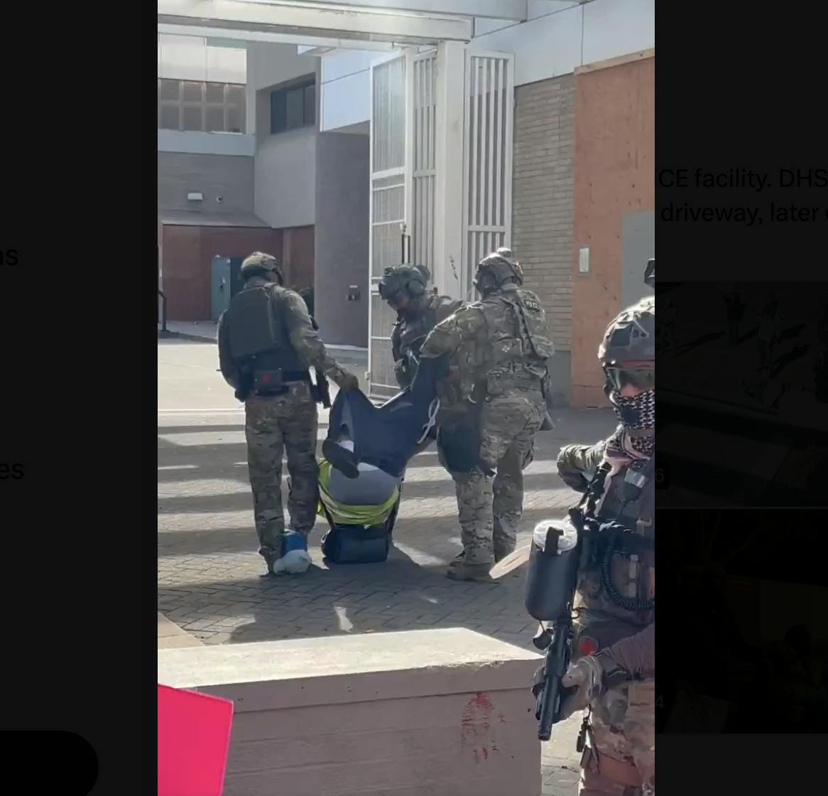 Three federal agents drag a man by his pants as his head hits the pavement.