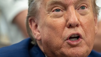 Donald Trump speaks while sitting at his desk in the Oval Office
