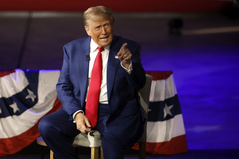 Donald Trump speaks animatedly and points to something or someone off screen