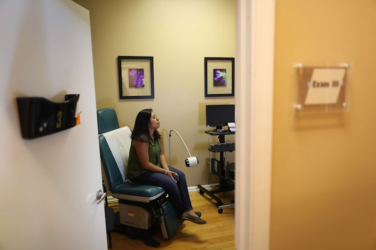 A woman sits in a doctor’s office at Planned Parenthood.