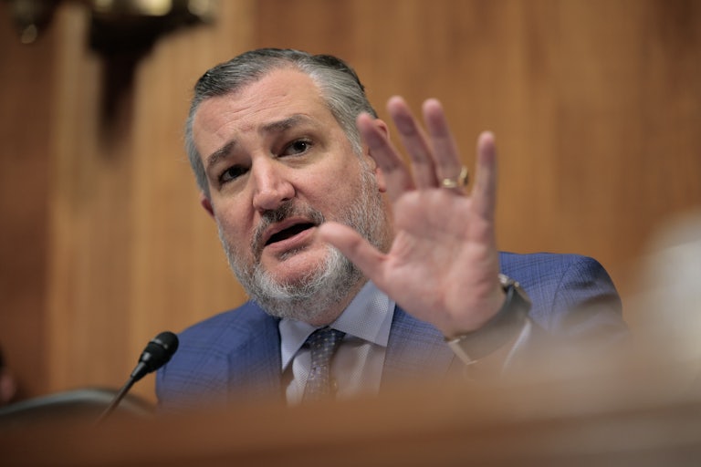 Senator Ted Cruz speaks in a congressional hearing and raises his hand for emphasis.