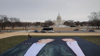 A large banner printed with a photo of Jeffrey Epstein and Donald Trump is laid out on the National Mall in front of the Capitol