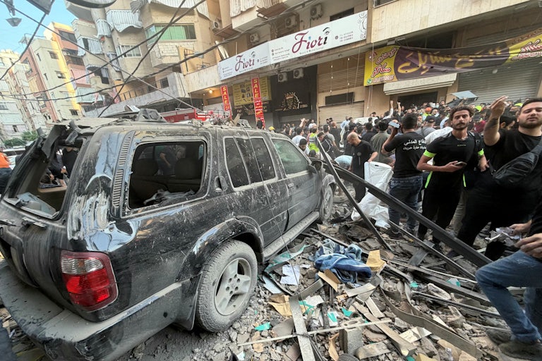People in Beirut gather near rubble after an Israeli strike on November 23, 2025.