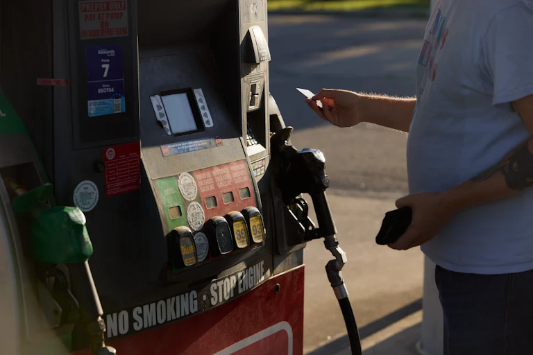 A man puts a credit card into a gas pump