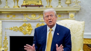 Donald Trump gestures and speaks while sitting in the Oval Office