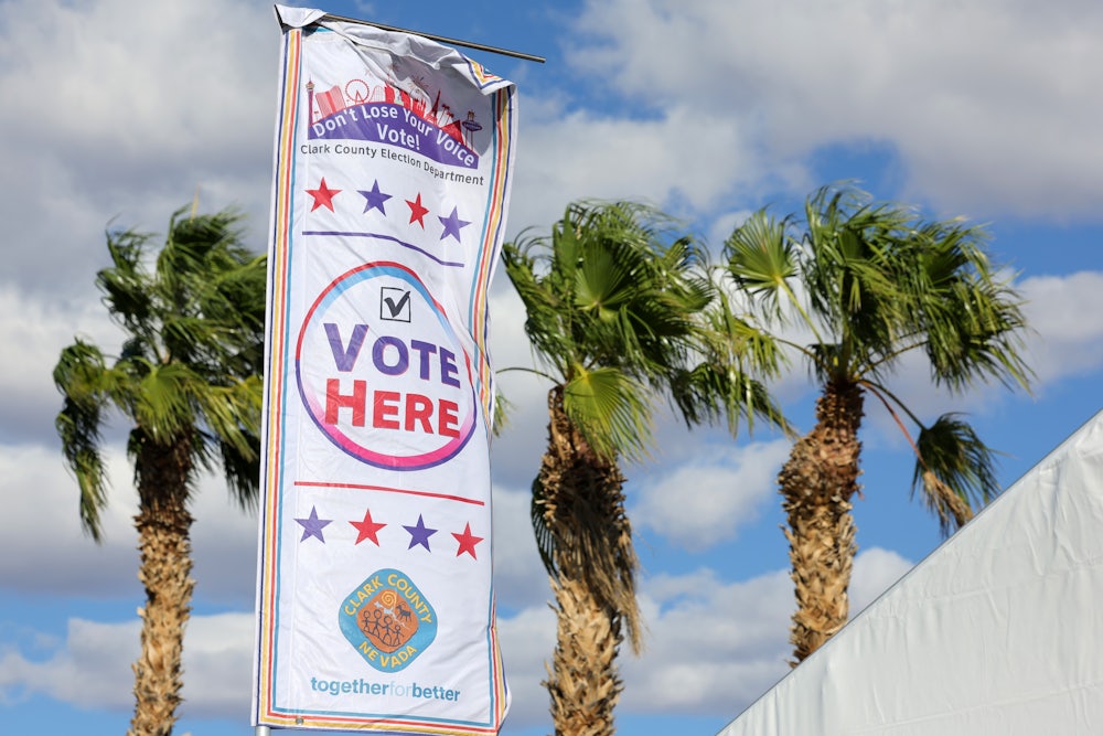 High winds whip a banner marking a voting site on the first day of in-person early voting at a tent at the Thunderbird Family Sports Complex on October 19, 2024 in Las Vegas, Nevada.