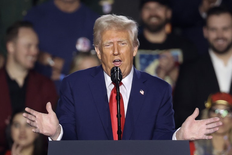 Donald Trump gestures while speaking at a podium