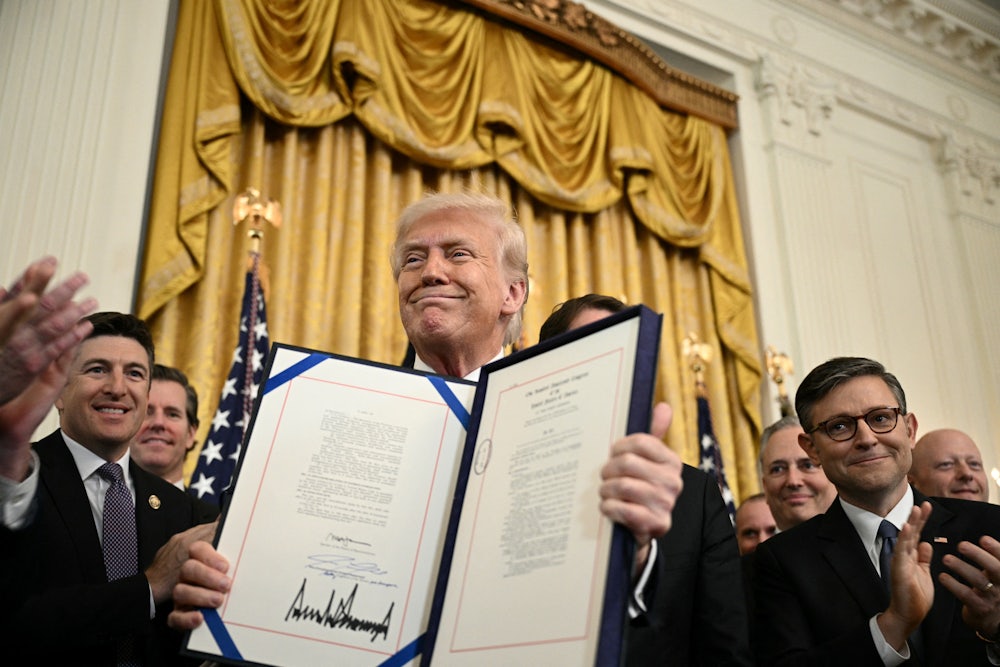 Donald Trump displays the GENIUS Act, which codifies the use of stablecoins -- cryptocurrencies pegged to stable assets like the US dollar or US bonds -- after signing it in the East Room of the White House.