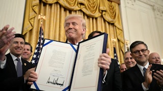 Donald Trump displays the GENIUS Act, which codifies the use of stablecoins -- cryptocurrencies pegged to stable assets like the US dollar or US bonds -- after signing it in the East Room of the White House.