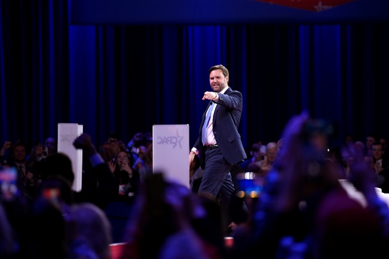 Vice President JD Vance smiles and points while walking off the stage at CPAC