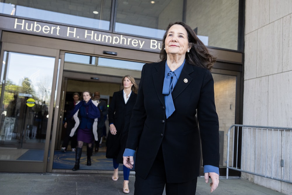 Diana DeGette walks out of the Hubert H. Humphrey Building, followed by others.