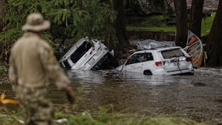 ehicles sit submerged as a search and rescue worker looks through debris for any survivors or remains of people swept up in the flash flooding in Texas.