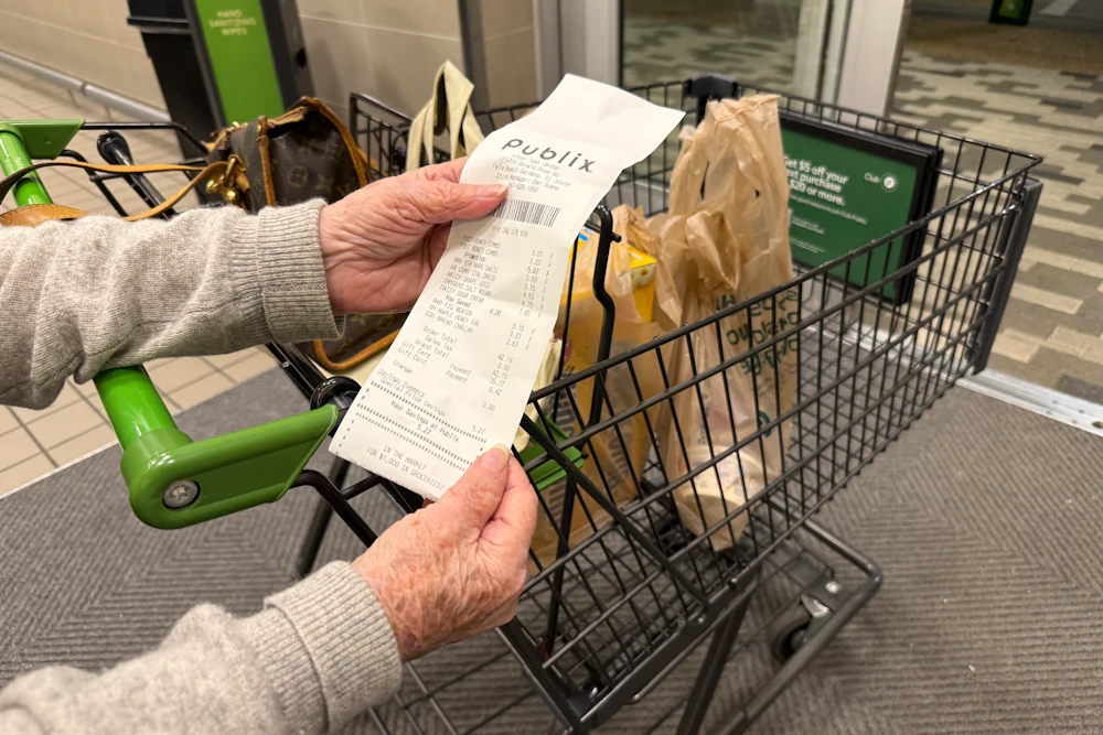 Mature woman reviewing receipt after shopping at Publix supermarket, Florida.