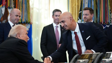Novo Nordisk CEO Mike Doustdar bends down to shake hands with Donald Trump, who is seated behind his desk in the White House Oval Office.