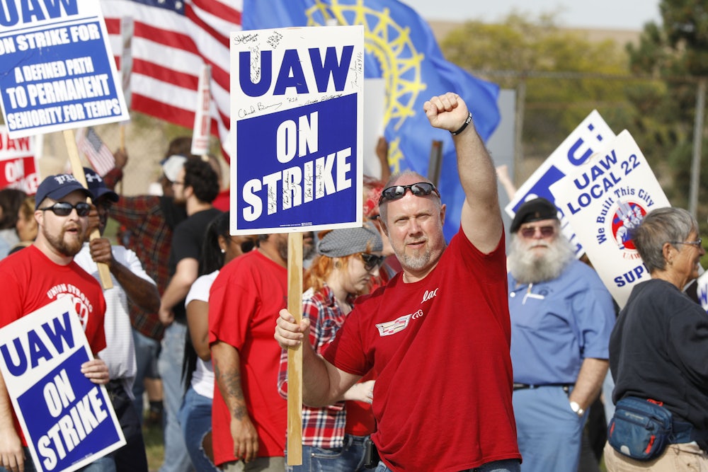 A United Auto Workers union member raises his fist on the picket line at the General Motors Flint Assembly plant.