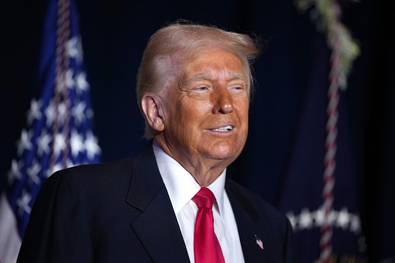 Donald Trump smiles weirdly. His spray tan is dark.