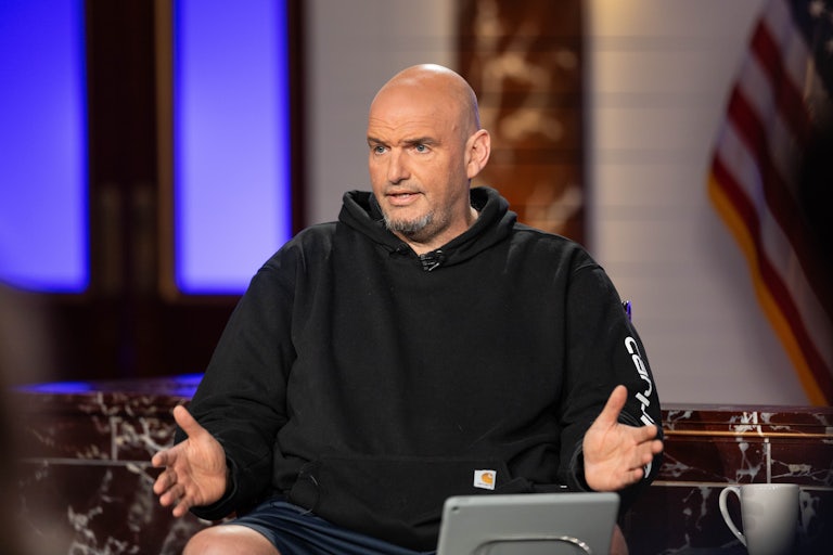 Senator John Fetterman speaks and splays his hands outward as if in defense.