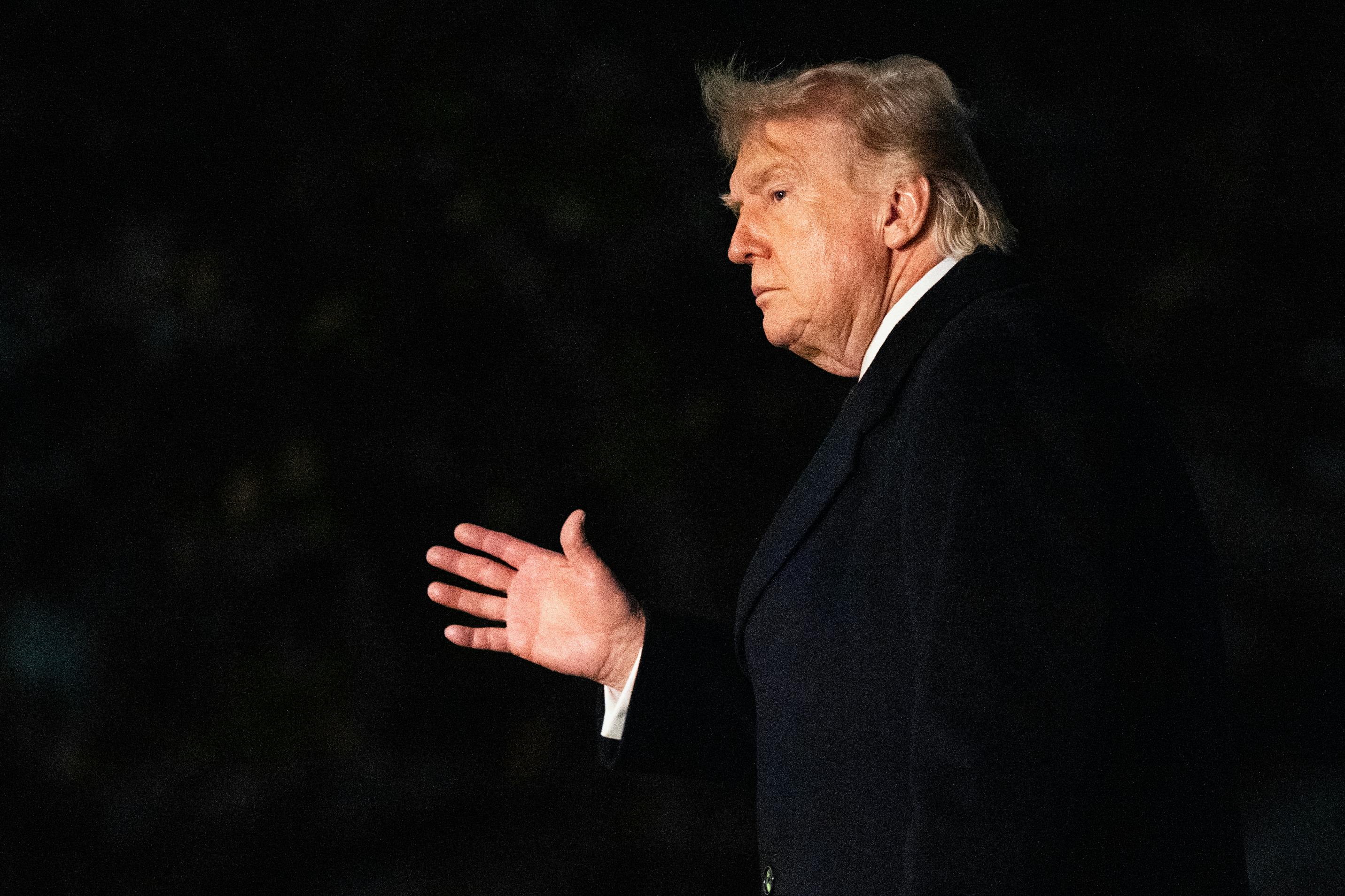 Donald Trump waves while walking outside the White House