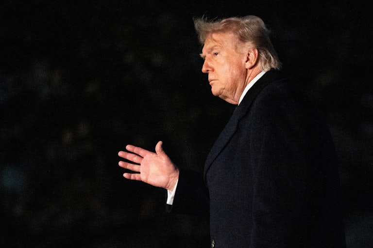 Donald Trump waves while walking outside the White House