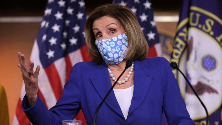 A masked Nancy Pelosi speaks at a news conference on Capitol Hill.