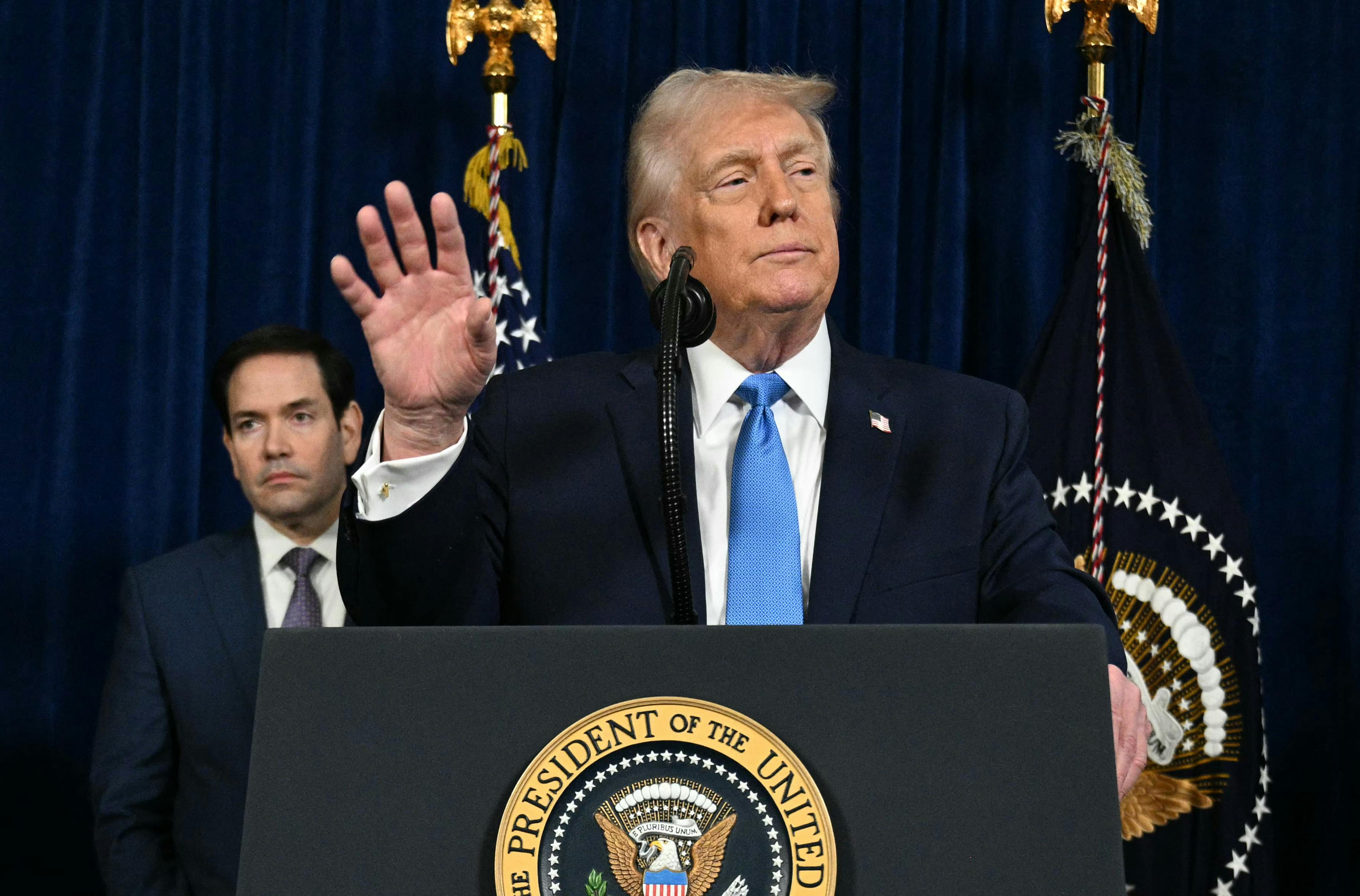 Donald Trump speaks to the press as Secretary of State Marco Rubio looks on following US military actions in Venezuela. 