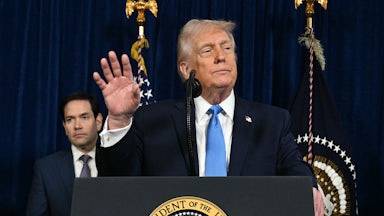 Donald Trump speaks to the press as Secretary of State Marco Rubio looks on following US military actions in Venezuela.