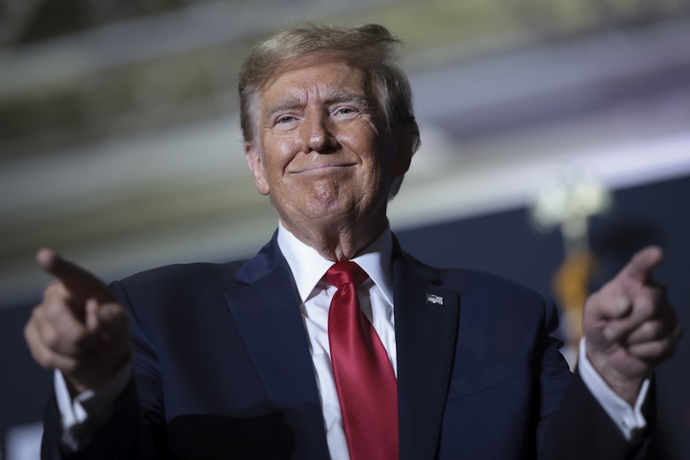 Donald Trump smiles and points his fingers out