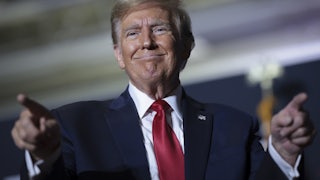 Donald Trump smiles and points his fingers out