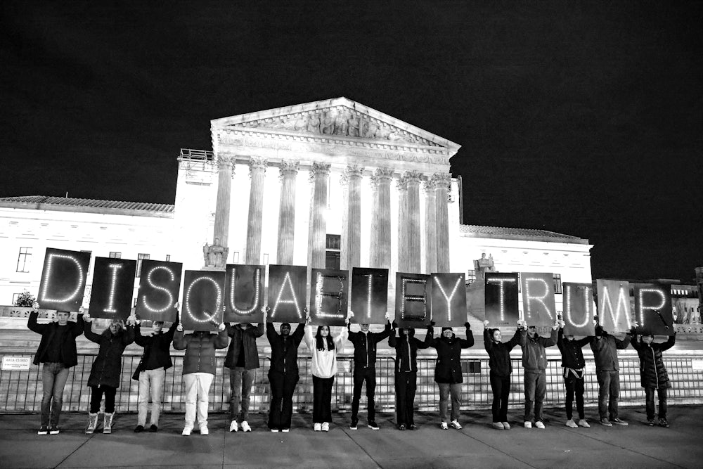 MoveOn members hold signs that read "Disqualify Trump" during a rally outside of the U.S. Supreme Court of the United States on February 01, 2024 in Washington, DC.