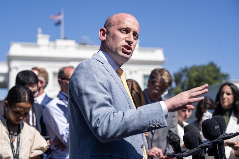 Stephen Miller gestures and looks to the side while speaking to reporters outside the White House