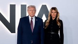 Donald Trump and Melania Trump pose for the cameras in front of a Melania backdrop during the premiere of her documentary at the Kennedy Center. Melania Trump purses her lips like crazy.