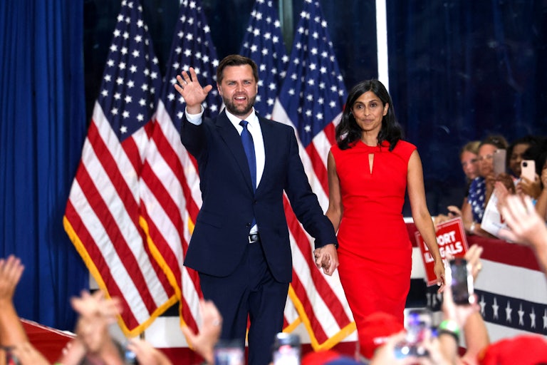 J.D. Vance holds hands with his wife and waves during a rally for Donald Trump
