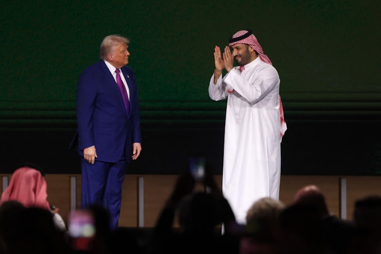 Donald Trump and Saudi Crown Prince Mohammed bin Salman stand next to each other on stage. MBS claps