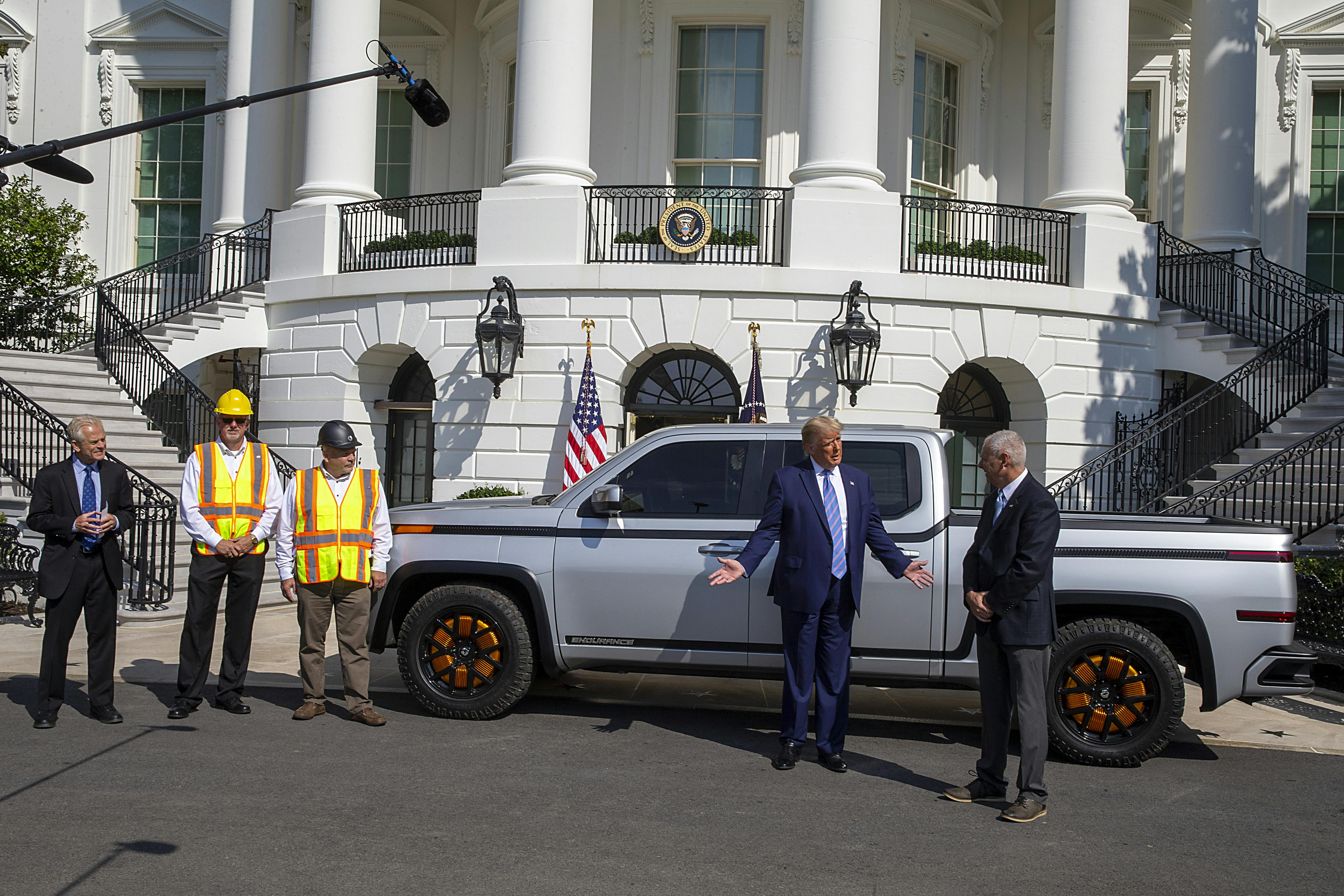 President Trump stands in front of an electric truck parked in front of the White House.