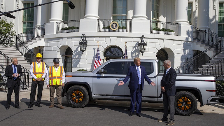 President Trump stands in front of an electric truck parked in front of the White House.