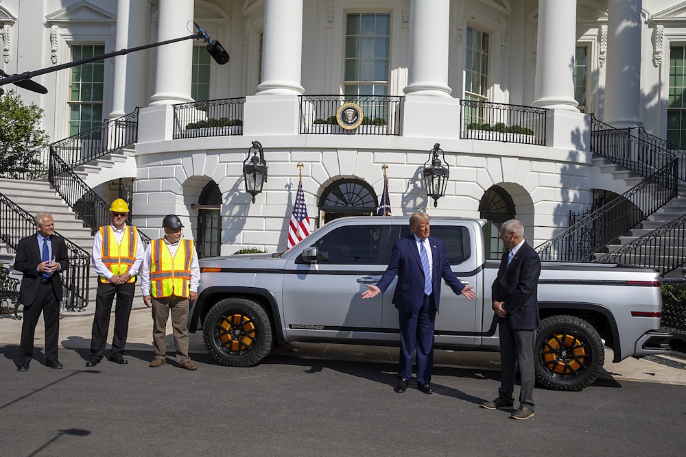 President Trump stands in front of an electric truck parked in front of the White House.