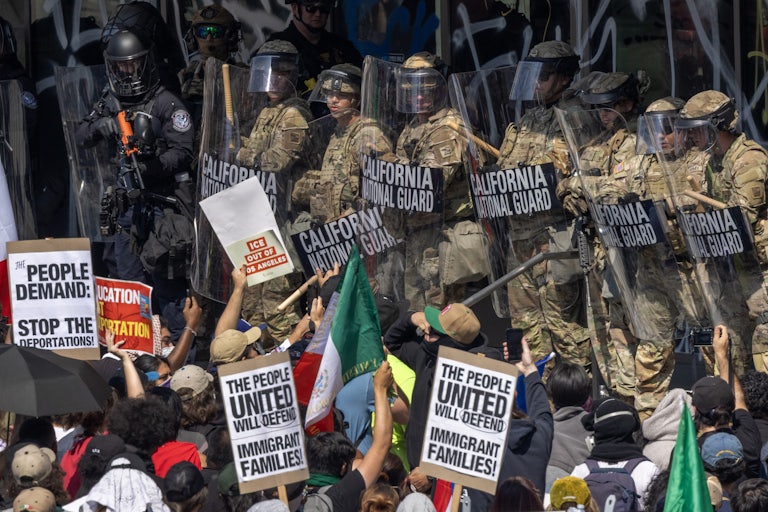 Protesters waving pro-immigration signs face off against National Guardsmen in Los Angeles