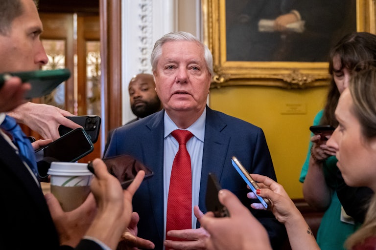 Senator Lindsey Graham stands in the Capitol while surrounded by reporters.