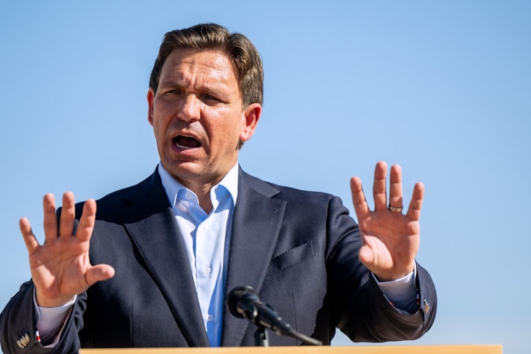 Florida Governor Ron DeSantis speaks animatedly and makes hand gestures at a lectern outdoors