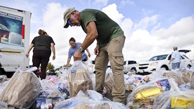 Volunteers organize bags of groceries at a food bank