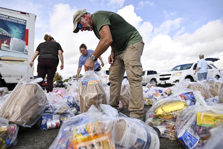 Volunteers organize bags of groceries at a food bank
