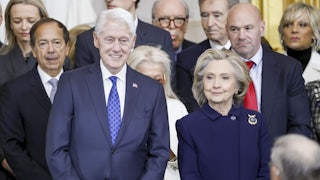 Hillary Clinton and Bill Clinton stand in a crowd