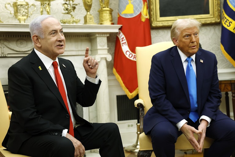 Donald Trump and Israeli Prime Minister Benjamin Netanyahu sit during a meeting in the Oval Office of the White House. Netanyahu points a finger in the air while speaking, as if to make a point.